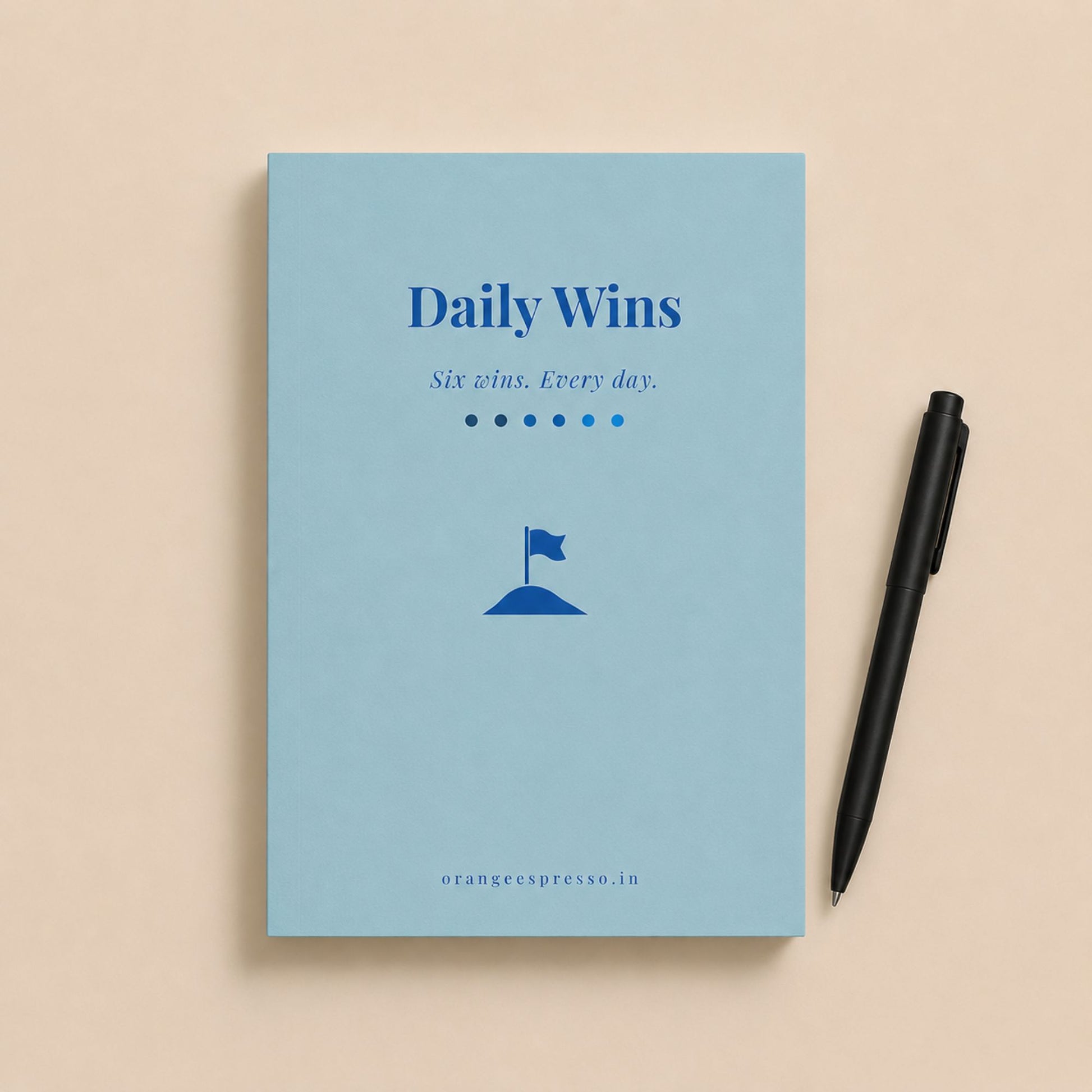 Notebook titled 'Daily Wins' with a pen on a beige background