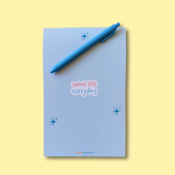 Orange Espresso daily to-do list notepad "Small Steps Everyday" front cover which is blue in colour and the photo is on a yellow background.